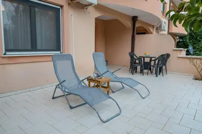 a patio with chairs and a table and a window at Apartment Qservice Petrovac in Budva