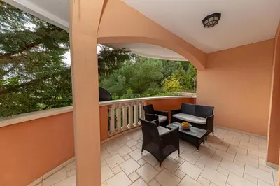 a balcony with chairs and a couch and a table at Apartment Qservice Petrovac in Budva