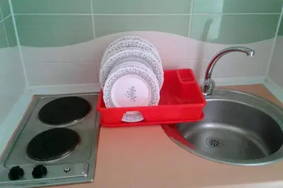 a kitchen sink with a red dish drainer in it at Villla Elkom, App 10 in Ulcinj