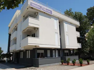 a white building with a sign on it at Villa Elkom, App 14 in Ulcinj