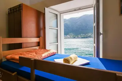 a bedroom with a bed with a view of the water at Montenegro Hostel 4U in Kotor