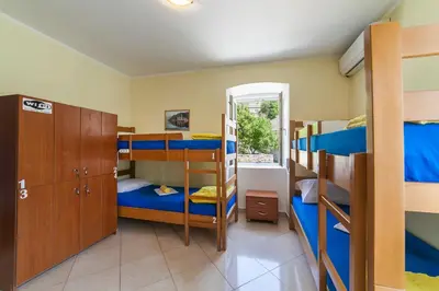 a room with several bunk beds and a mirror at Montenegro Hostel 4U in Kotor