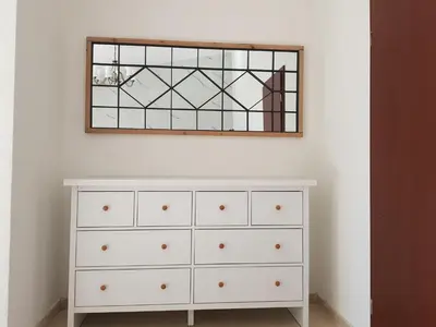 a bedroom with a dresser and a mirror on the wall at Villa Alisa in Dobra Voda