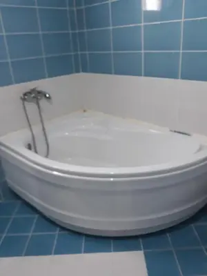 a white toilet in a blue tiled bathroom at Villa Alisa in Dobra Voda