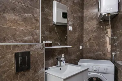 a bathroom with a sink and a washing machine at Apartments BEATRICE Rafailovici in Rafailovici