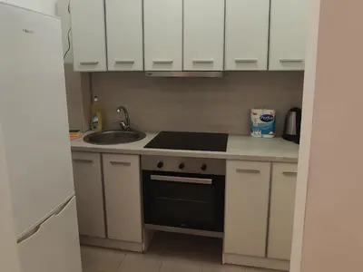 a kitchen with white cabinets and a stove and a sink at Apartments BEATRICE Rafailovici in Rafailovici