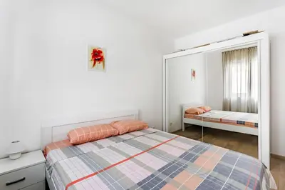 a bedroom with a bed and a mirror at Apartments BEATRICE Rafailovici in Rafailovici