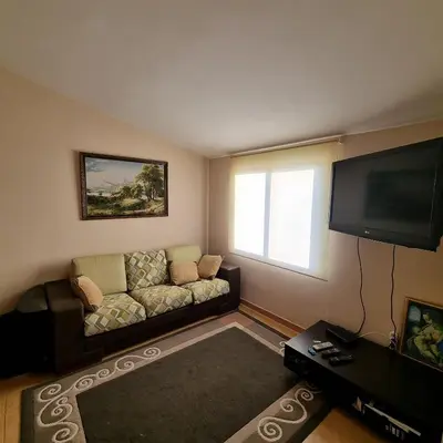 a living room with a couch and a flat screen tv at Апартаменты Anturage с отдельным входом in Dobra Voda