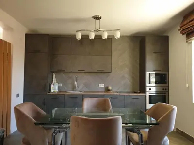 a kitchen with a glass table and some chairs at Апартаменты Anturage с отдельным входом in Dobra Voda