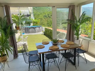 a dining room with a table and chairs on a balcony at Apartmani Avanti Becici in Becici