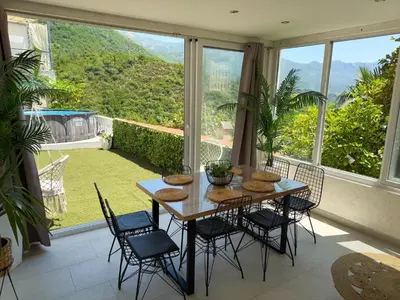 a table and chairs in a room with a view at Apartmani Avanti Becici in Becici