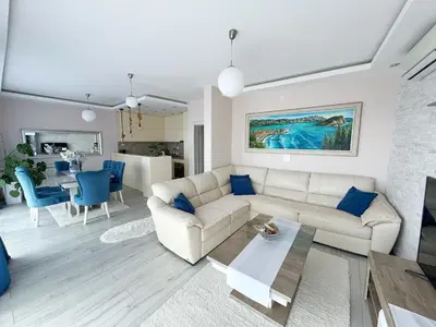 a living room with a white couch and blue chairs at Apartmani Avanti Becici in Becici