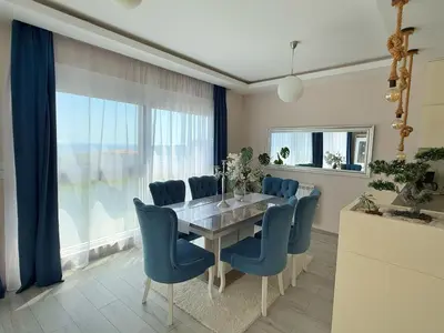 a dining room with a table and blue chairs at Apartmani Avanti Becici in Becici