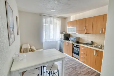 a kitchen with wooden cabinets and a white counter top at Bright, Romantic & Super Stylish Old Town Flat with Seaview & Shared Terrace in Kotor