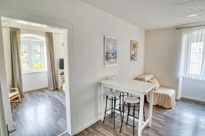 a living room with a white table and stools at Bright, Romantic & Super Stylish Old Town Flat with Seaview & Shared Terrace in Kotor