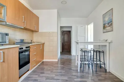 a kitchen with wooden cabinets and bar stools at Bright, Romantic & Super Stylish Old Town Flat with Seaview & Shared Terrace in Kotor