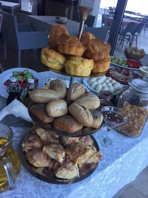 a table with three tiers of breads and pastries at Love Live Hotel in Sutomore