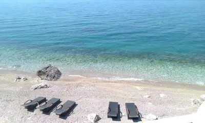 a group of lounge chairs on a beach at Love Live Hotel in Sutomore