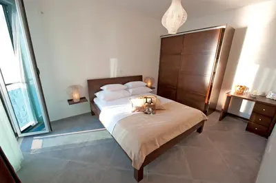 a bedroom with a bed with two candles on it at Love Live Hotel in Sutomore