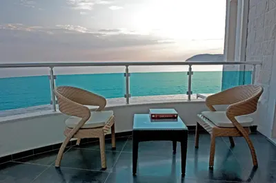 two chairs and a table on a balcony with the ocean at Love Live Hotel in Sutomore