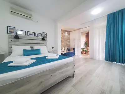 a bedroom with a large bed with blue pillows at Egon Apartments in Budva