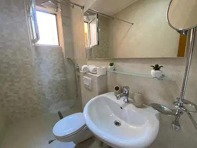 a bathroom with a sink and a toilet and a mirror at Egon Apartments in Budva