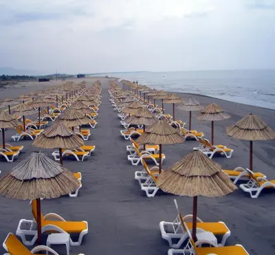 a row of chairs and umbrellas on a beach at Villa Elkom, App.17 in Ulcinj