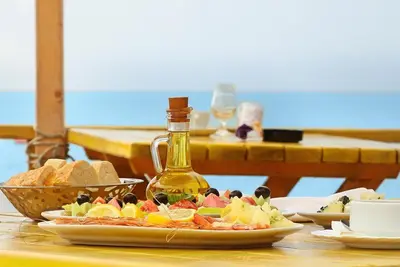 a table with a plate of food and a bottle of oil at Villa Elkom, App.17 in Ulcinj