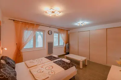 a bedroom with two beds and a table in it at Palm Point Apartment in Petrovac na Moru