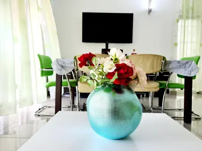 a blue vase with red and white flowers on a table at Olive Garden Apartment in Petrovac na Moru