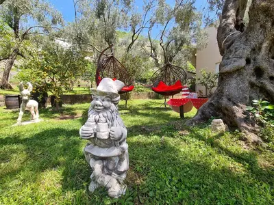 a statue of a cat wearing a santa hat in a yard at Olive Garden Apartment in Petrovac na Moru