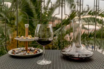 a table with a glass of wine and a plate of food at Olive Garden Apartment in Petrovac na Moru
