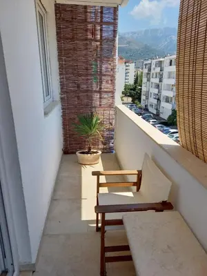 a balcony with a chair and a view of a city at Apartman Bojana in Bar