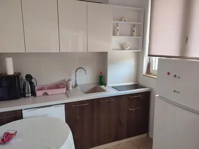 a small kitchen with white cabinets and a sink at Apartman Bojana in Bar