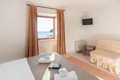 a bedroom with a bed and a window with the ocean at R club Apartments Old Town Budva in Budva
