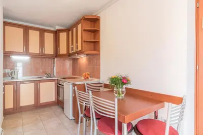 a small kitchen with a wooden table and chairs at R club Apartments Old Town Budva in Budva