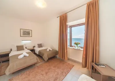 a hotel room with two beds and a window at R club Apartments Old Town Budva in Budva