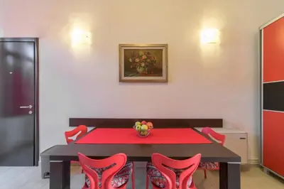 a dining room with a red table and red chairs at R club Apartments Old Town Budva in Budva