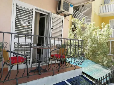 a balcony of a building with two chairs and a heater at Mint Apartment studio in Petrovac na Moru