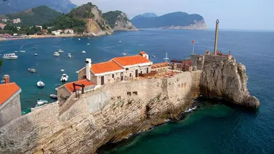 a building on the side of a cliff in the water at Mint Apartment studio in Petrovac na Moru
