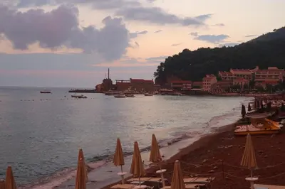 a beach with chairs and umbrellas on the beach at Mint Apartment studio in Petrovac na Moru