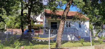 a house with a fence in front of it at Forest house in Sutomore
