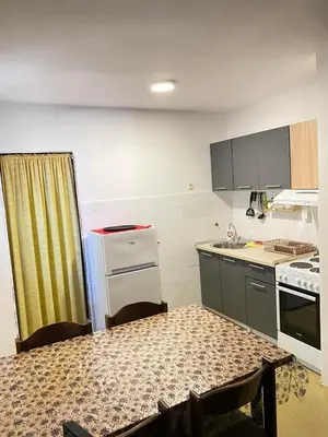 a small kitchen with a table and a counter top at Forest house in Sutomore