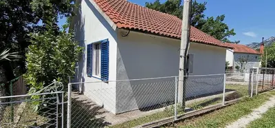 a white house with a fence in front of it at Forest house in Sutomore