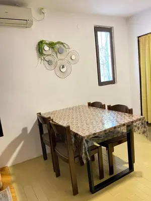 a dining room table with chairs and a table and a window at Forest house in Sutomore