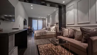 a living room with a bed and a couch in a room at Vivid Blue Serenity Resort in Sveti Stefan
