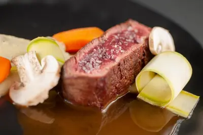 a piece of meat and vegetables on a plate at Vivid Blue Serenity Resort in Sveti Stefan