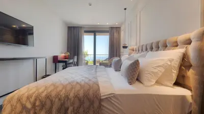a bedroom with a large bed with a large headboard at Vivid Blue Serenity Resort in Sveti Stefan