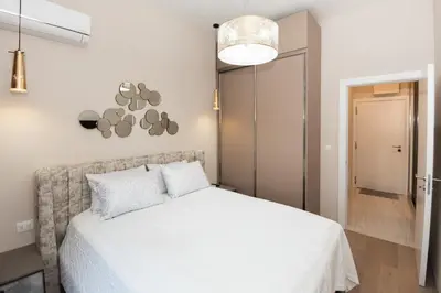 a bedroom with a white bed and a light fixture at Montesun Boka Apartments in Budva