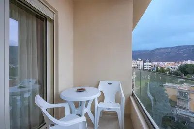 a balcony with a table and two chairs and a window at Montesun Boka Apartments in Budva